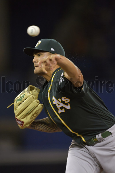 Tattoos adorn the catching arm of Oakland Athletics Starting