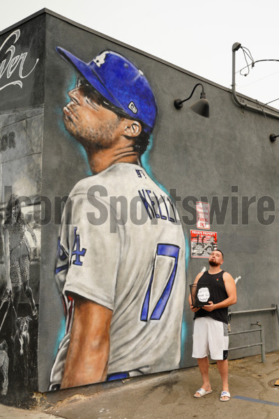 LOS ANGELES, CA - SEPTEMBER 12: A fan posing for a picture in front of  mural of Los Angeles Dodgers pitcher Joe Kelly (17) making his pouty face  mocking the Astros as