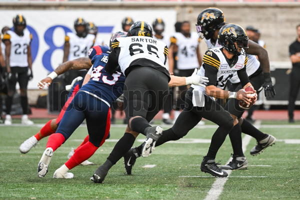 Hamilton Tiger-Cats defensive back Javien Elliott hands the ball